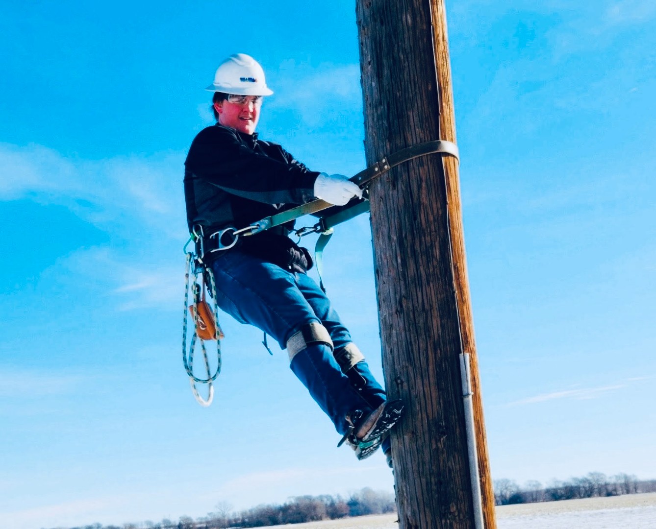 A student on a powerline pole as part of their CEOs program with the Wahoo Utilities department.